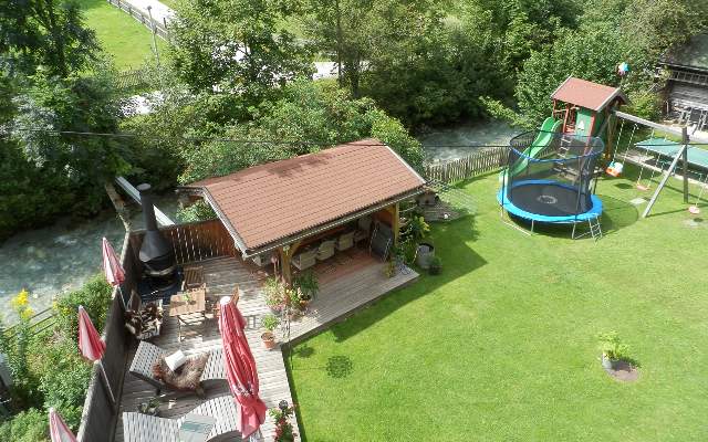 Well-kept garden with play equipment, trampoline, barbecue hut and sun loungers