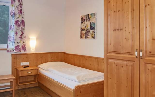 Mehrbettzimmer mit Einzelbetten und Stockbetten, Dusche und WC